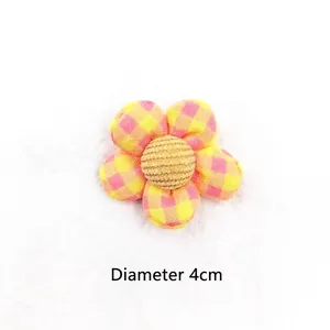 Macro detail of a 4cm checkered fabric flower showing yellow and pink petals for DIY hair craft