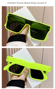 Detail of neon green oversized sunglasses showing the thick frame and dark grey lenses