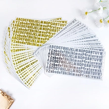Close-up of gold and silver alphabet stickers with daisy decor for DIY crafts