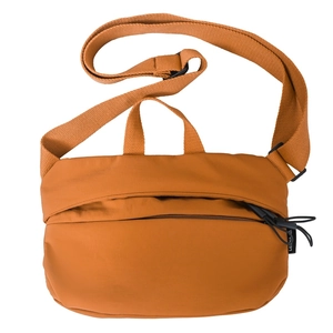 Detail of orange-brown nylon crossbody dumpling bag with adjustable strap and top handle