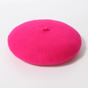 Bovenaanzicht van een felle roze wollen baret met een klassieke staart op de bovenkant