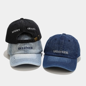 Close-up of embroidered letters on vintage washed denim baseball caps in three colors