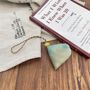 Detail of zongzi shape fabric pendant with gradient blue-green tie-dye and colorful cord