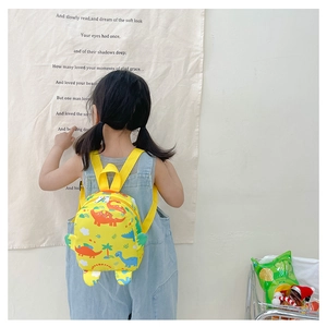 Detailed back view of a yellow toddler backpack with cute colorful dinosaur patterns