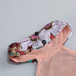 Gros plan de broderie florale à paillettes sur tulle avec boutons de dos élégants