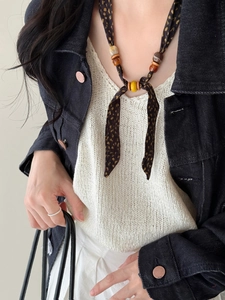 Detail of ethnic style leopard print chiffon necklace with wooden and ceramic beads