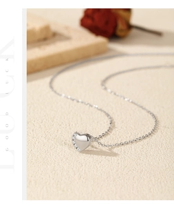 Dettaglio della collana a cuore in argento S925 lucido con zirconi su sfondo di pietra