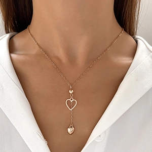 Rose gold Y-necklace with hollow and solid heart pendants worn on a female model