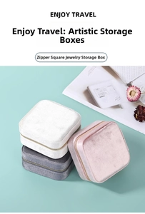 Close-up of three square velvet jewelry boxes in white grey and pink with gold zippers