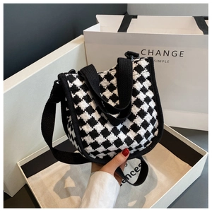 Close-up of checkerboard knit hobo bag in a branded gift box with matching shopping bag