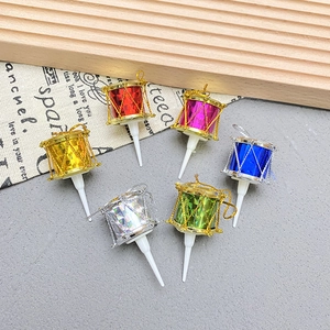 Close-up of colorful mini drum cake toppers with glitter finish for Christmas decor