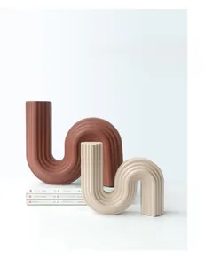 Détail de vases en céramique modernes en U avec rayures verticales en terre cuite et crème