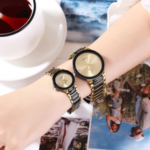 Detail of gold and black couple's quartz watches featuring metal link bands and rhinestones