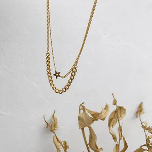 Close-up of double layer titanium steel necklace with star pendant in gold finish