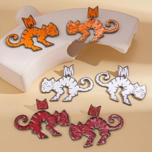 Three pairs of colorful abstract striped cat earrings in orange, white, and deep red finishes
