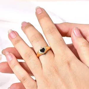 18K gold plated stainless steel wide band ring featuring a black epoxy heart centerpiece