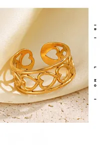 Detailed macro view of gold hollow heart ring on silk with brushed metal texture