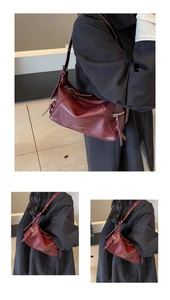Detailed close-up of wine red vintage leather shoulder bag with adjustable strap and zip