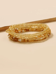 Detailed close-up of handmade bohemian waist chain with multi-color beads on sand surface