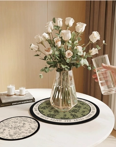 Detail of floral absorbent leather coaster with Happy Every Day text in home setting