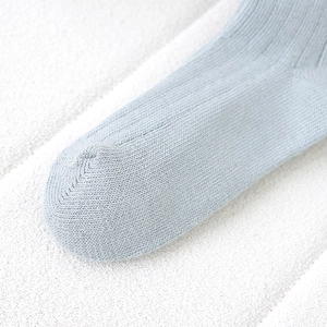 Close-up of light blue cotton knit socks showing detailed toe seam and fabric texture
