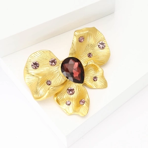 Exquisite gold butterfly brooch with deep red pear-shaped gemstone and purple rhinestones