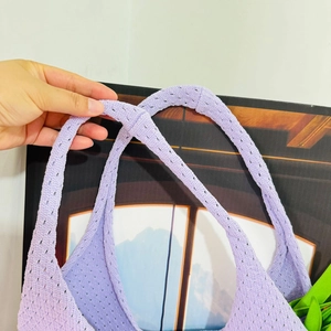 Detail shot showing the reinforced connection and soft texture of a purple knitted tote bag