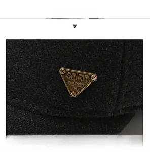 Macro shot of bronze eagle emblem on black winter baseball cap with thick wool texture