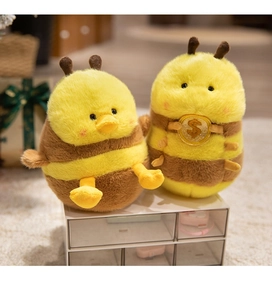 Close-up of cute plush bee duck keychains with striped texture and soft embroidery details