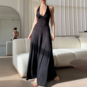 Detail of elegant backless halter neck dress with adjustable ties and flowy black fabric