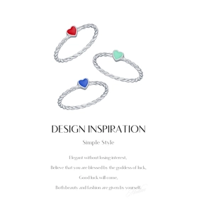 Detailed view of three twisted S925 silver rings with red, green, and blue enamel hearts