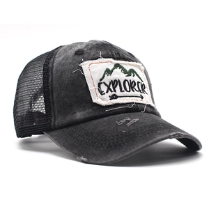 Close-up of distressed baseball cap with mesh back and explorer mountain patch detail