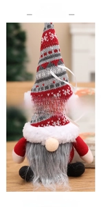 Dettaglio di uno gnomo di Natale appeso con berretto in maglia rossa e barba grigia