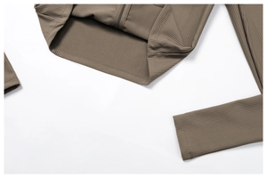 Detail of metal zipper and ribbed knit texture on a khaki slim yoga jacket
