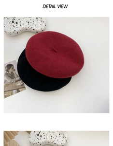 Detail view of wool berets in red and black styled with artistic fashion accessories