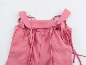 Détail d'une robe rose montrant les bretelles nouées réglables et la fermeture éclair invisible