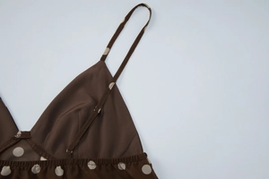 Détail des bretelles fines réglables et du motif à pois sur ce caraco marron élégant