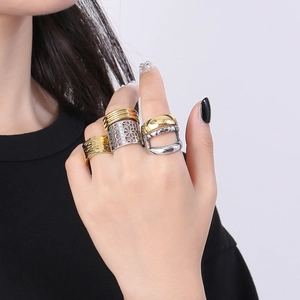 Detailopname van gouden en zilveren geometrische titanium stalen ringen gedragen door model