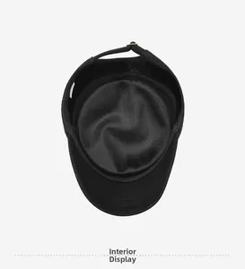 Interior detail of black cotton flat cap showing breathable lining and adjustable buckle
