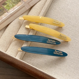 Detailed macro of acetate hair clips with golden Barrette La France engraving and metal base