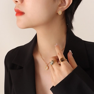 Bohemian gold jewelry set featuring white cat eye stone necklace, earrings, and rings