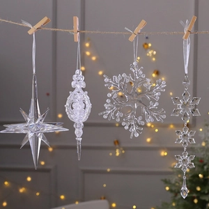 Clear acrylic Christmas ornaments in snowflake and star shapes hanging on a jute rope