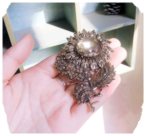 Detailed view of sunflower brooch featuring brown crystals and central gemstone