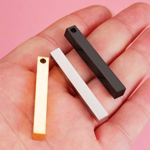 Pendentif barre 3D en acier inoxydable doré argenté et noir tenu dans la main