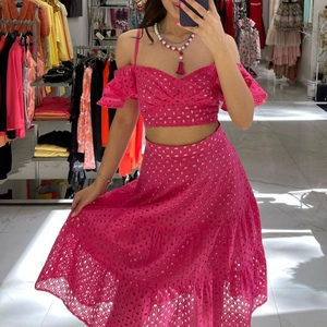Ensemble rose deux pièces avec broderie anglaise, haut court et jupe longue à volants