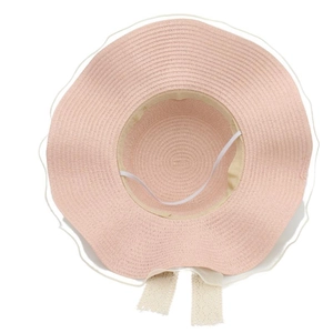 Detailed view of pink straw hat with white lace bow and adjustable windproof strap