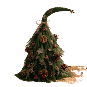 Mini tabletop Christmas tree with curved top, pine cones, red berries and wooden ornaments