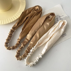 Three-piece satin twist headband set in champagne, brown, and ivory silk-like fabric