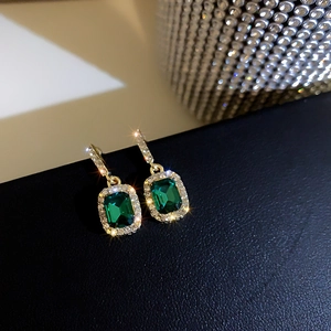 Orecchini dorati eleganti con grandi smeraldi quadrati e diamanti brillanti