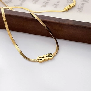 Detail of 18K gold snake chain necklaces featuring SIS and MOM letter pendants